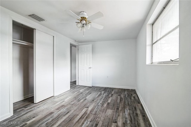 unfurnished bedroom featuring ceiling fan, a closet, and hardwood / wood-style flooring