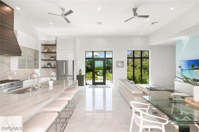 kitchen with modern cabinets, open shelves, backsplash, white cabinetry, and appliances with stainless steel finishes