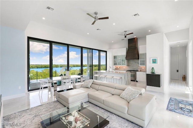 living room featuring visible vents, recessed lighting, ceiling fan, and a water view