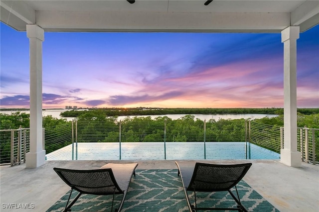 view of patio with a balcony and a water view