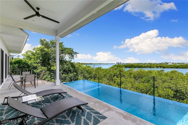 view of swimming pool featuring outdoor dining space, a patio, a ceiling fan, and a water view