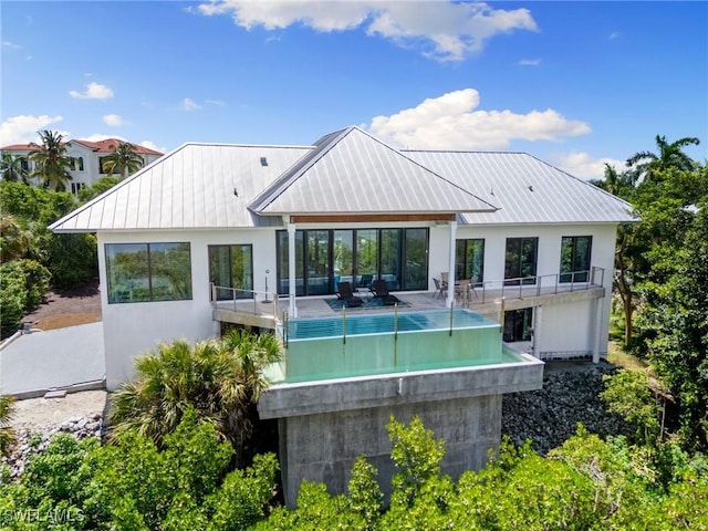 rear view of house with a standing seam roof and metal roof