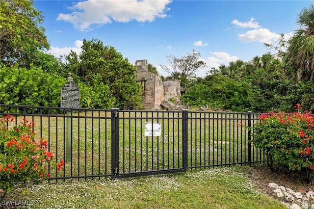 view of gate with a yard and fence