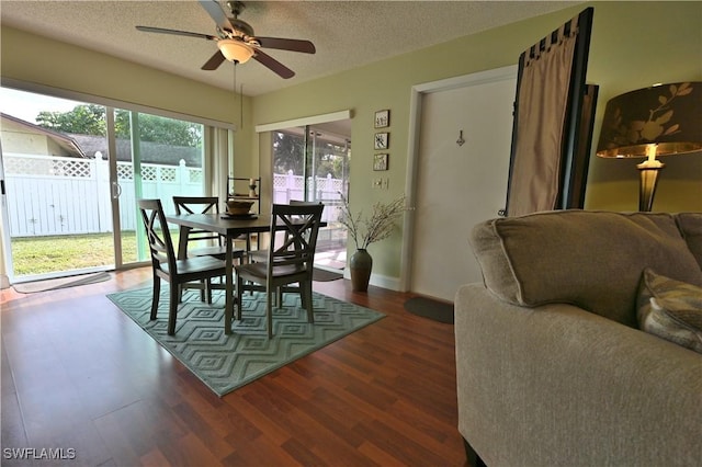 dining room with a textured ceiling, ceiling fan, and dark wood-type flooring