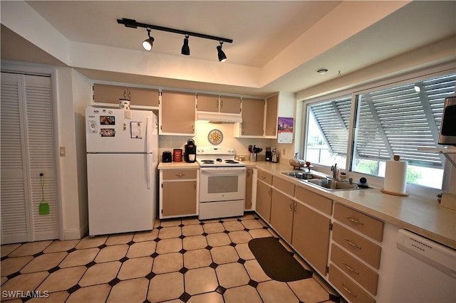 kitchen with white appliances, track lighting, and sink