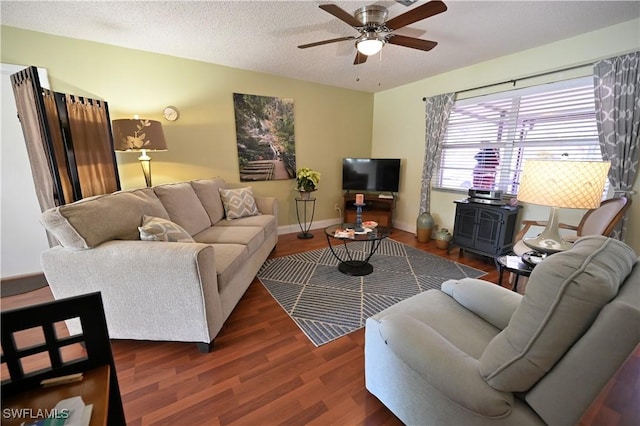 living room featuring dark hardwood / wood-style floors, ceiling fan, and a textured ceiling