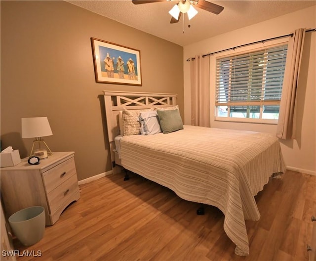 bedroom featuring ceiling fan, a textured ceiling, and light wood-type flooring