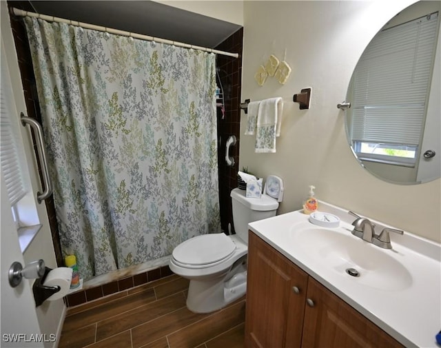 bathroom with walk in shower, vanity, and toilet