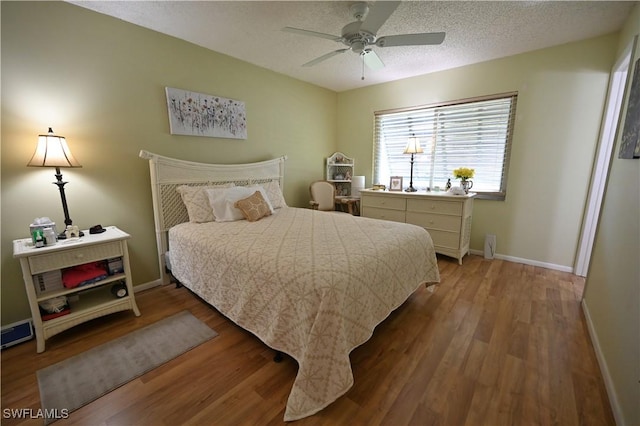 bedroom with hardwood / wood-style floors, a textured ceiling, and ceiling fan