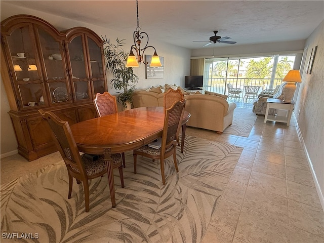 dining space with light tile patterned floors and ceiling fan with notable chandelier