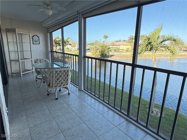 unfurnished sunroom with a water view and ceiling fan