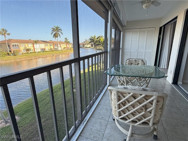 sunroom / solarium featuring a water view and ceiling fan