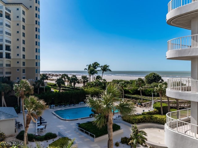 view of swimming pool featuring a water view and a beach view