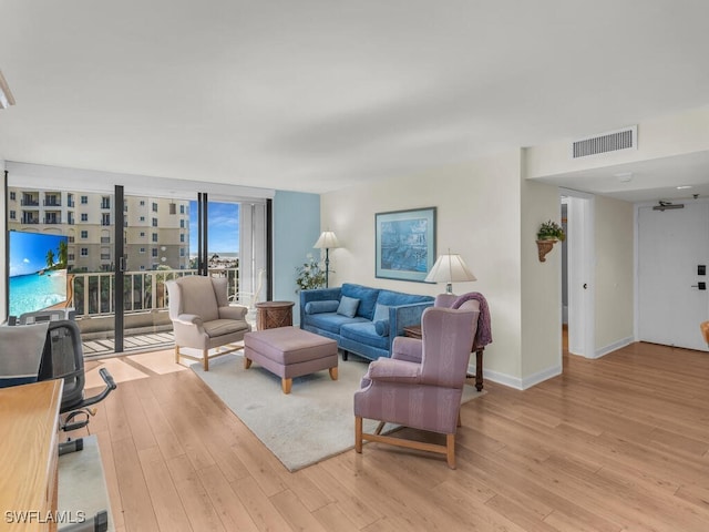 living room featuring light hardwood / wood-style flooring and a wall of windows