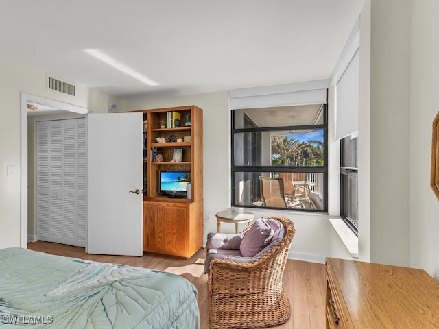 bedroom with light hardwood / wood-style floors and a closet