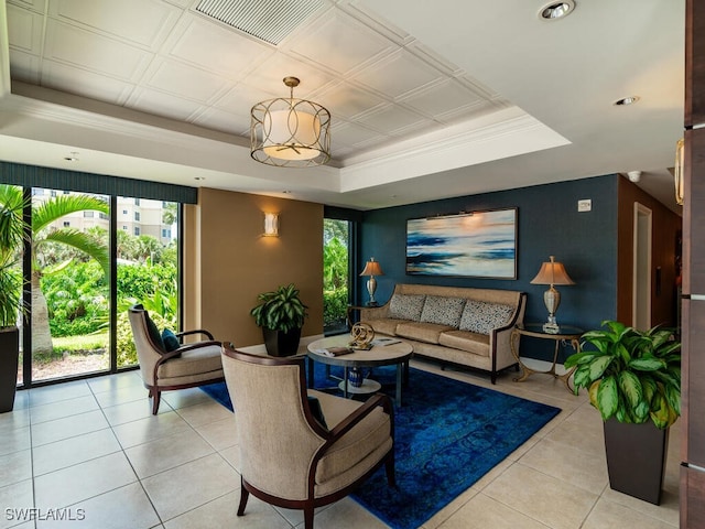 tiled living room with ornamental molding and a tray ceiling