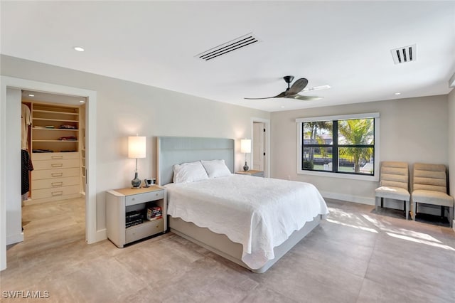 bedroom with a walk in closet and ceiling fan