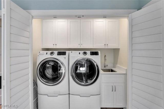 laundry room with washer and clothes dryer, cabinets, and sink