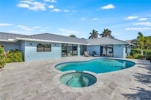 view of swimming pool featuring a patio area and an in ground hot tub