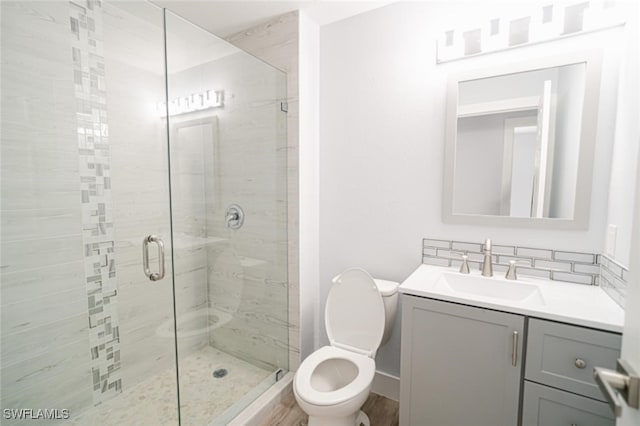 bathroom with hardwood / wood-style floors, vanity, an enclosed shower, and toilet