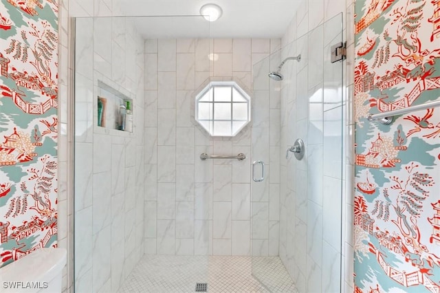 bathroom with toilet and a shower with shower door