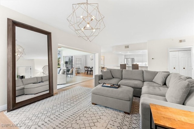 living room featuring an inviting chandelier and light wood-type flooring