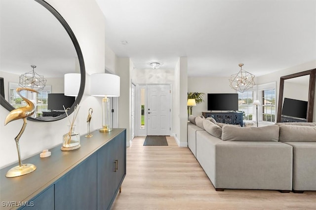 living room featuring a chandelier and light hardwood / wood-style flooring