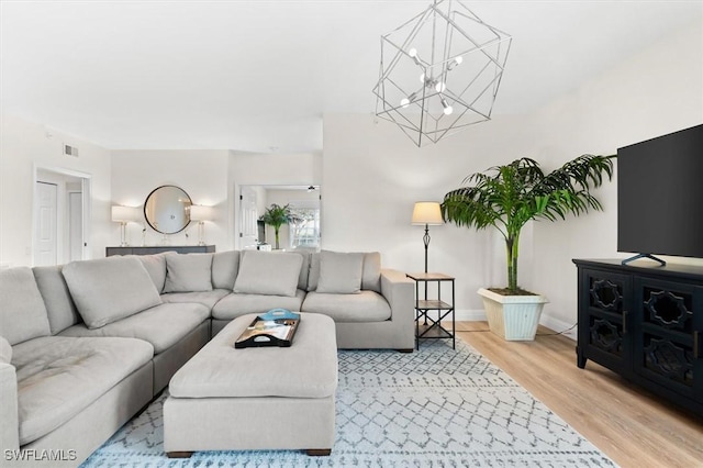 living room featuring wood-type flooring and an inviting chandelier