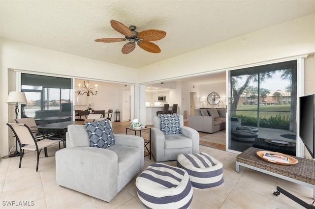 tiled living room with a textured ceiling and ceiling fan with notable chandelier