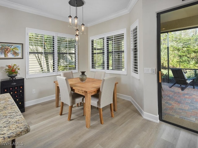 dining area with light wood-type flooring and crown molding