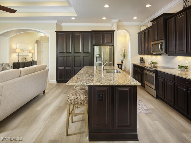 kitchen with sink, stainless steel appliances, light hardwood / wood-style flooring, a center island with sink, and dark brown cabinets