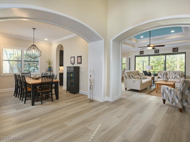 dining room featuring ceiling fan with notable chandelier, light hardwood / wood-style floors, and crown molding