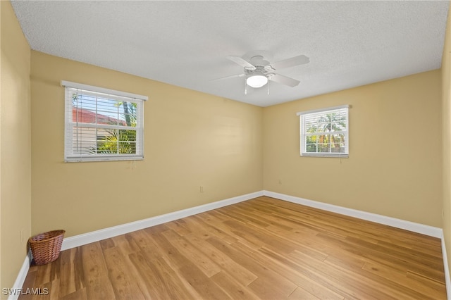 unfurnished room with ceiling fan, a textured ceiling, and light wood-type flooring