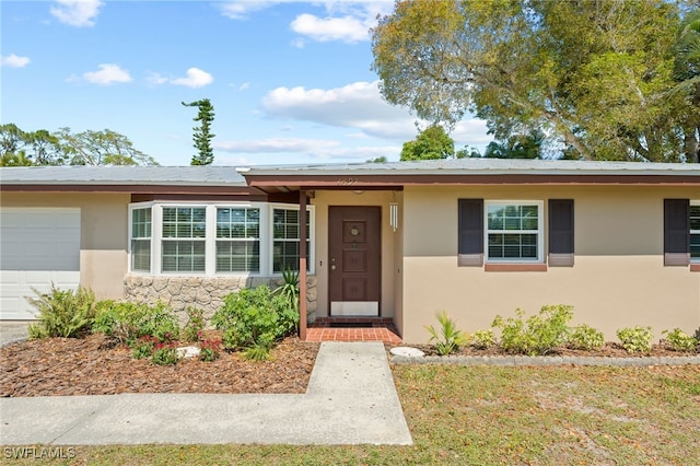 ranch-style house with a garage and stucco siding