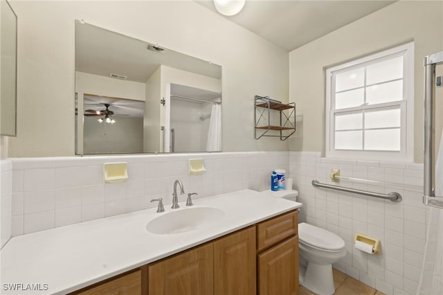 bathroom featuring vanity, ceiling fan, tile walls, tile patterned flooring, and toilet