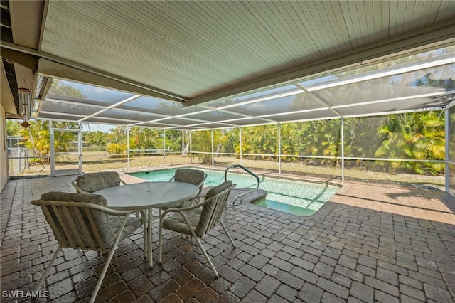 view of pool with glass enclosure and a patio area