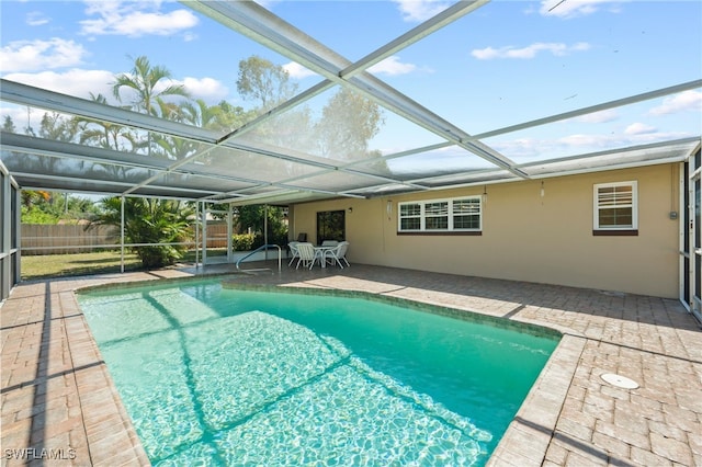 view of swimming pool featuring a patio and a lanai