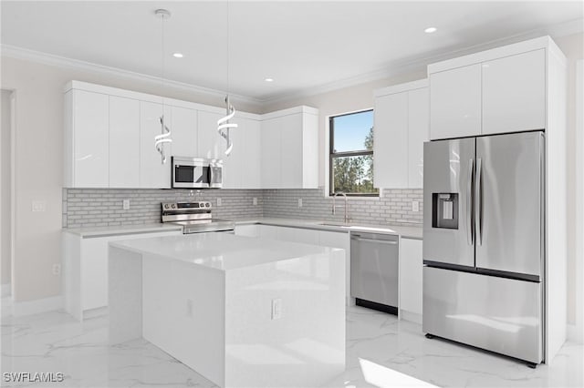 kitchen with stainless steel appliances, a kitchen island, pendant lighting, and white cabinets