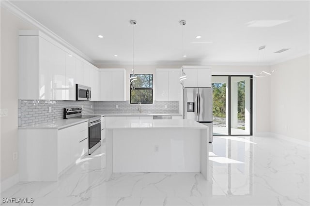 kitchen featuring pendant lighting, appliances with stainless steel finishes, white cabinetry, a healthy amount of sunlight, and a kitchen island