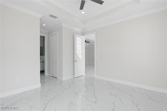 empty room featuring a tray ceiling, crown molding, and ceiling fan