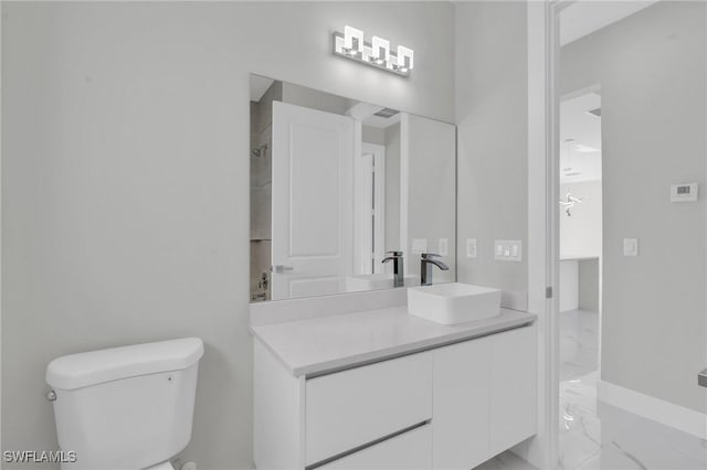 bathroom featuring marble finish floor, vanity, and toilet