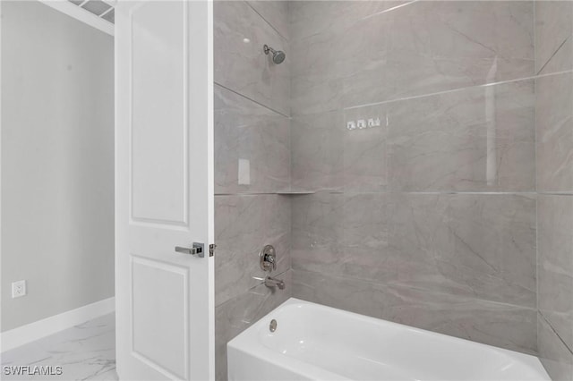 bathroom featuring marble finish floor, baseboards, and bathing tub / shower combination