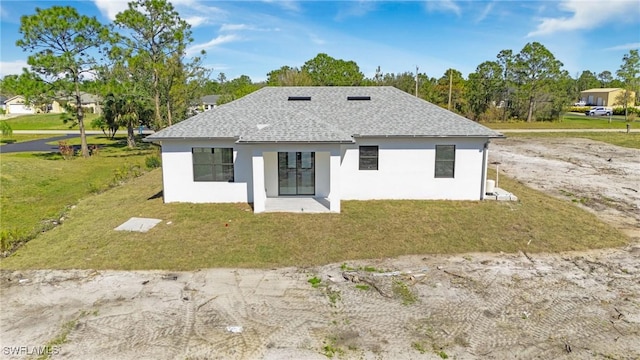 rear view of house featuring a yard