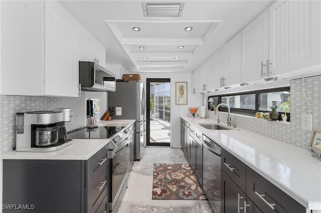 kitchen with white cabinets, appliances with stainless steel finishes, a healthy amount of sunlight, and sink