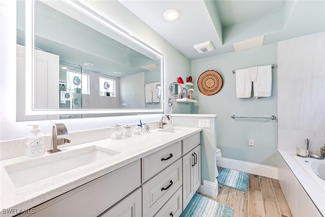 full bathroom featuring vanity, shower with separate bathtub, and toilet