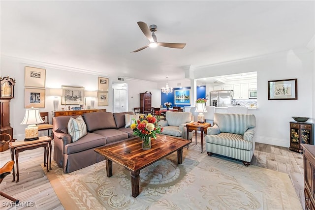 living room with ornamental molding, ceiling fan with notable chandelier, and light wood-type flooring