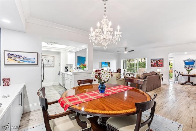 dining room with ceiling fan with notable chandelier, ornamental molding, and light hardwood / wood-style floors