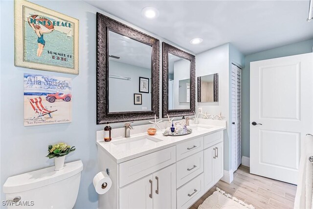 bathroom featuring vanity, wood-type flooring, and toilet