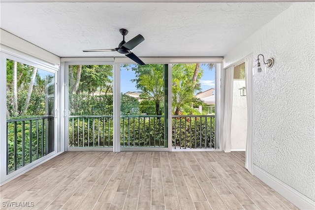 788 Willowbrook Dr Unit 502, Naples, FL 34108 - unfurnished sunroom with a textured wall, healthy amount of natural light, wood finished floors, and a textured ceiling