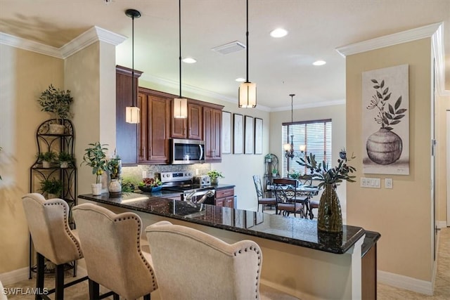6502 Monterey Pt Unit 202, Naples, FL 34105 - kitchen with stainless steel appliances, a peninsula, dark stone countertops, backsplash, and pendant lighting